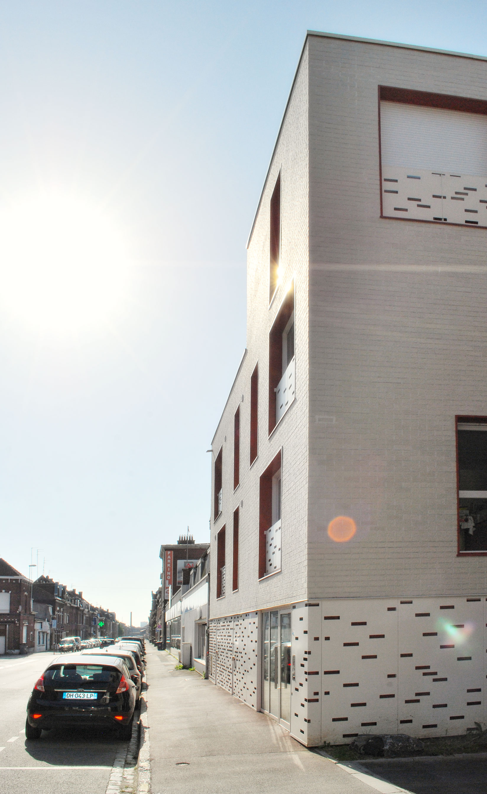 Angle de la façade en briques blanche des 11 logements collectifs à Tourcoing