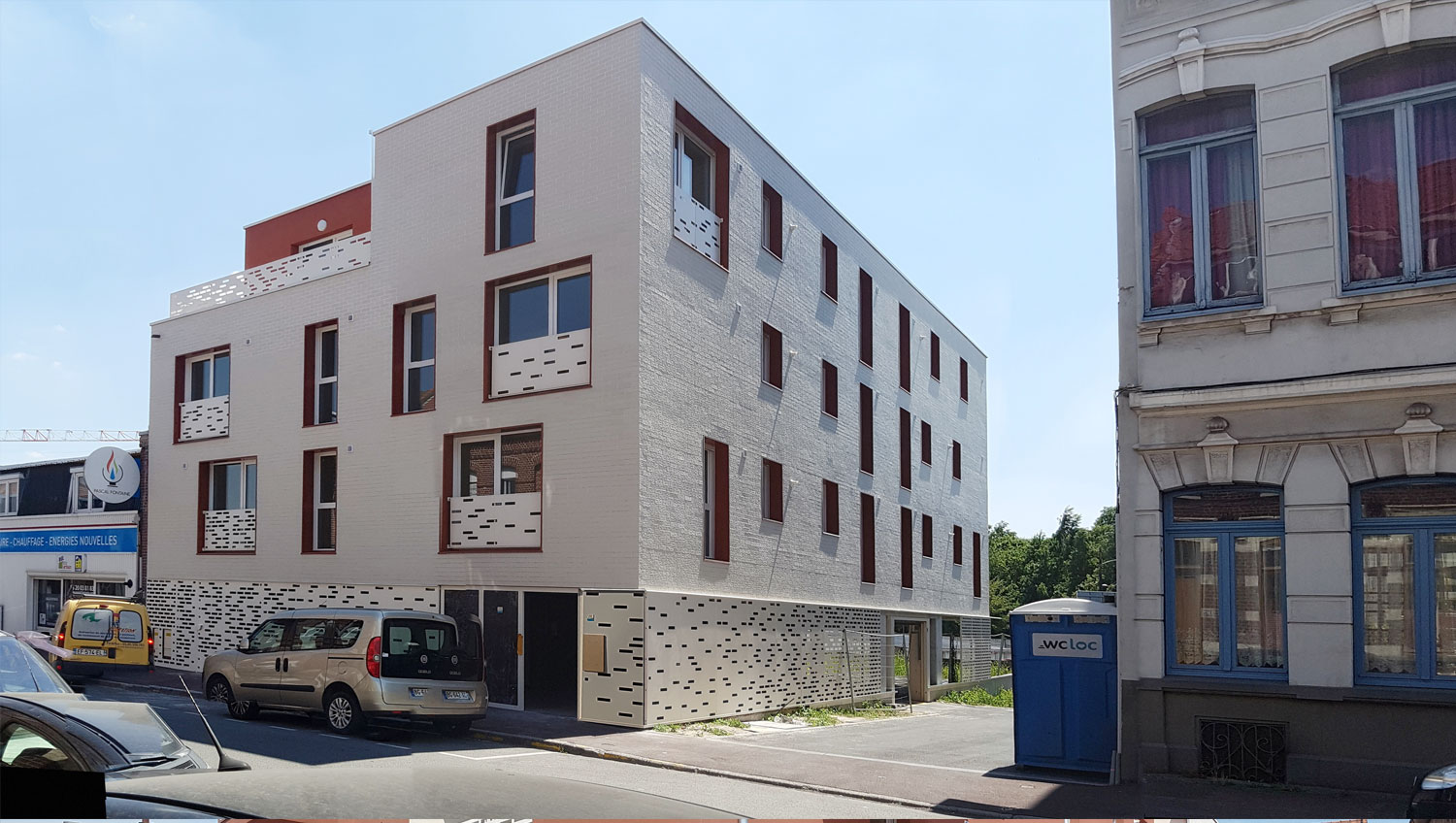 Façade en briques claires et encadrements rouges des 11 logements collectifs à Tourcoing