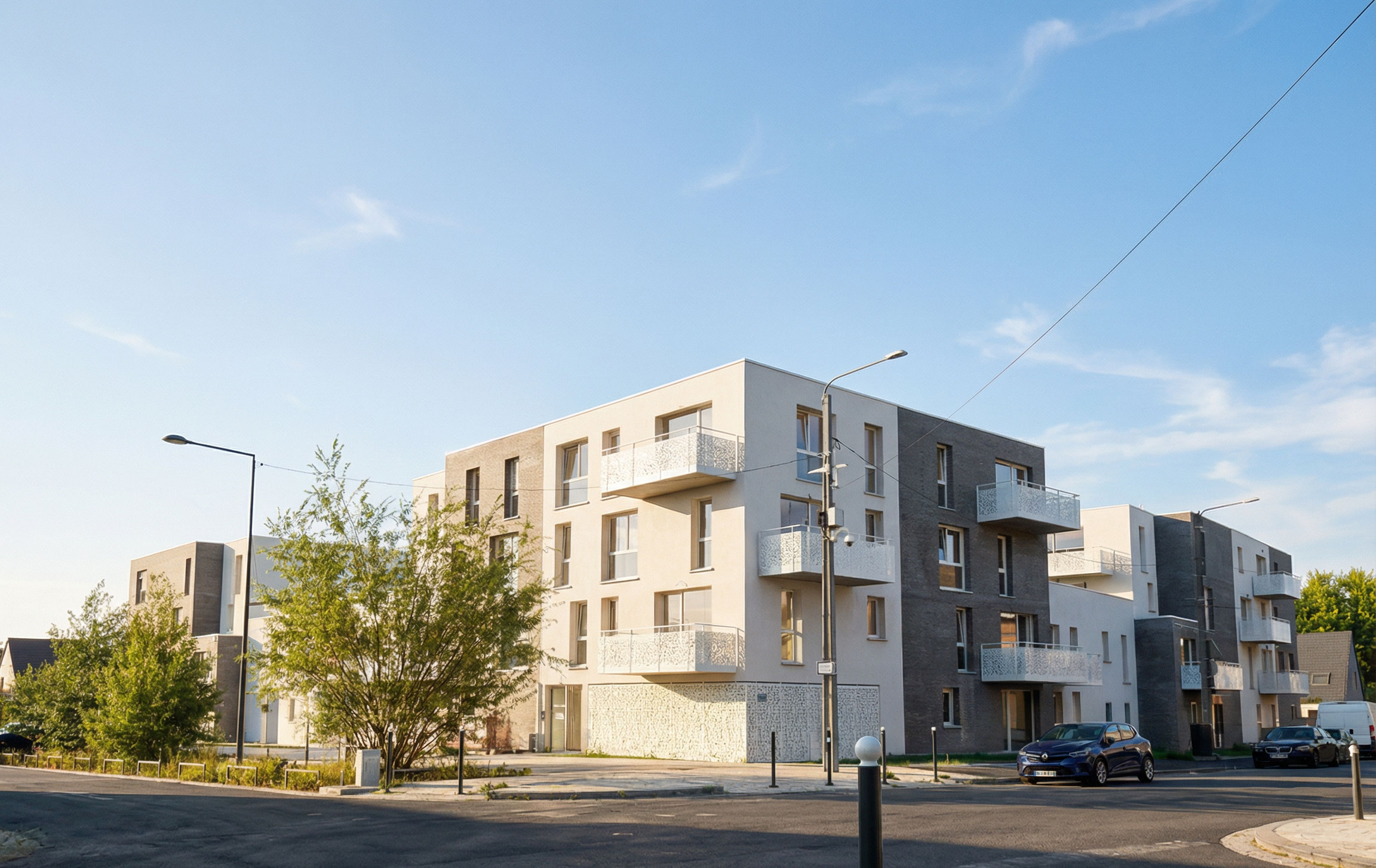 Vue de l'angle urbain de l'opération Flanelle à Wattrelos : 69 logements collectifs avec toitures végétalisées et îlot paysager central, projet de reconversion ZAC La Lainière - Handouche & Bréard architectes